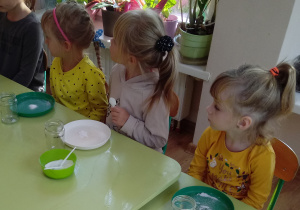 Dzieci słuchają instrukcji słownej do wykonania eksperymentu